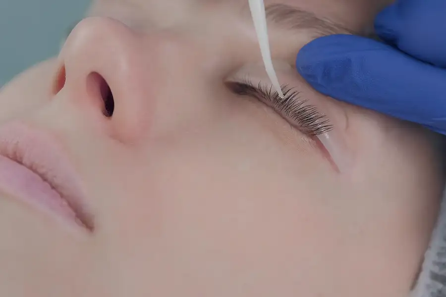 close up of young client's face - beautician is applying a lash lift - Central Illinois